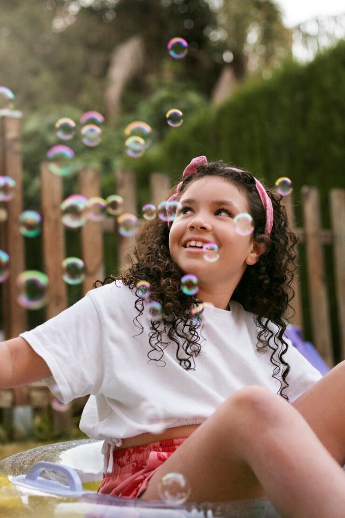 Girl sitting and playing with bubbles